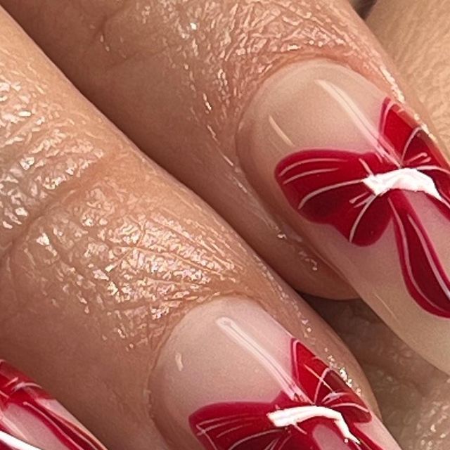 Bold and Refined: Elegant Nail Design with Vibrant Red Butterfly Motifs on a Nude Base.