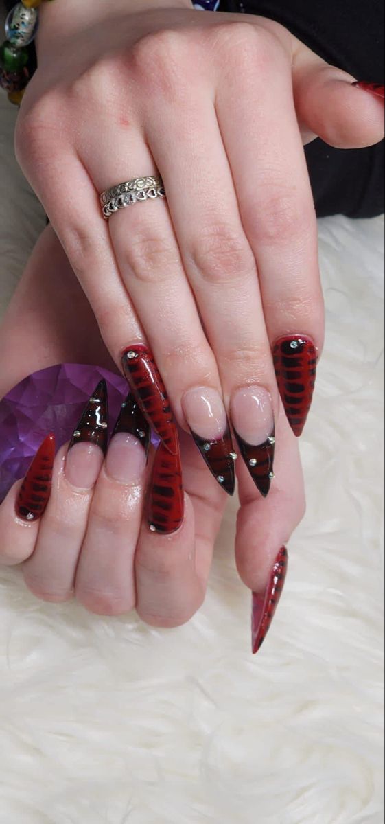 Bold and Elegant Long Tapered Nail Design in Red and Black with Intricate Patterns.