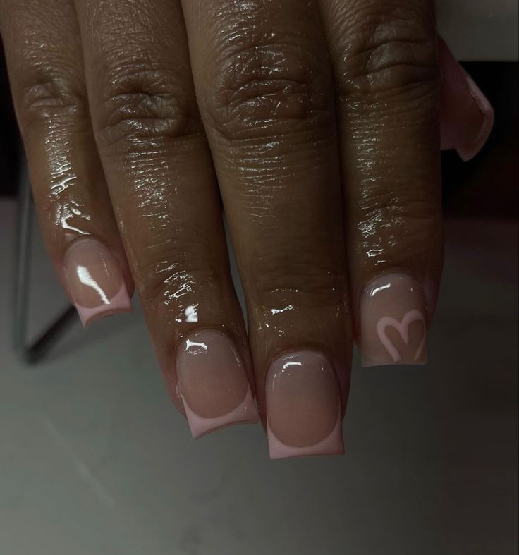 Chic Glossy Nude Nails with Pink Tips and Heart Motifs for Effortless Elegance.