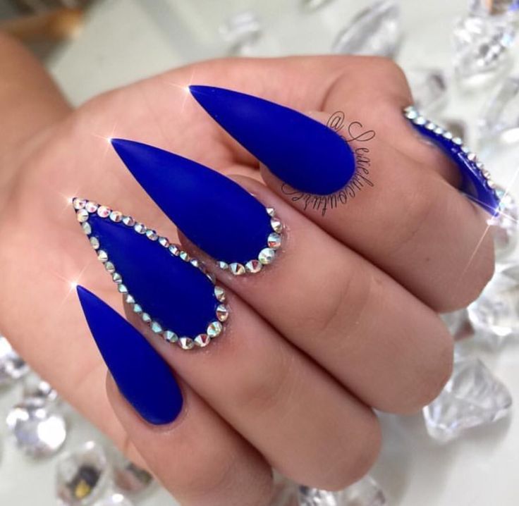 Glamorous Vibrant Blue Matte Stiletto Nails Adorned with Rhinestones.