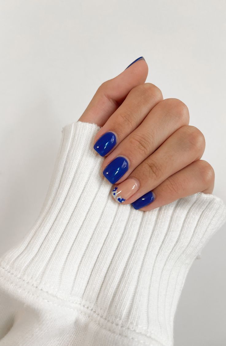 Bold Blue Floral Nail Design with Glossy Finish and Modern Two-Tone Palette.