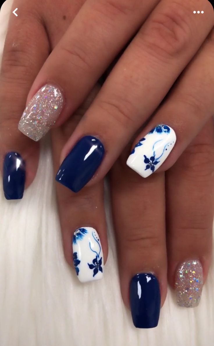 Sophisticated Navy and White Floral Nail Design with Glitter Accents.