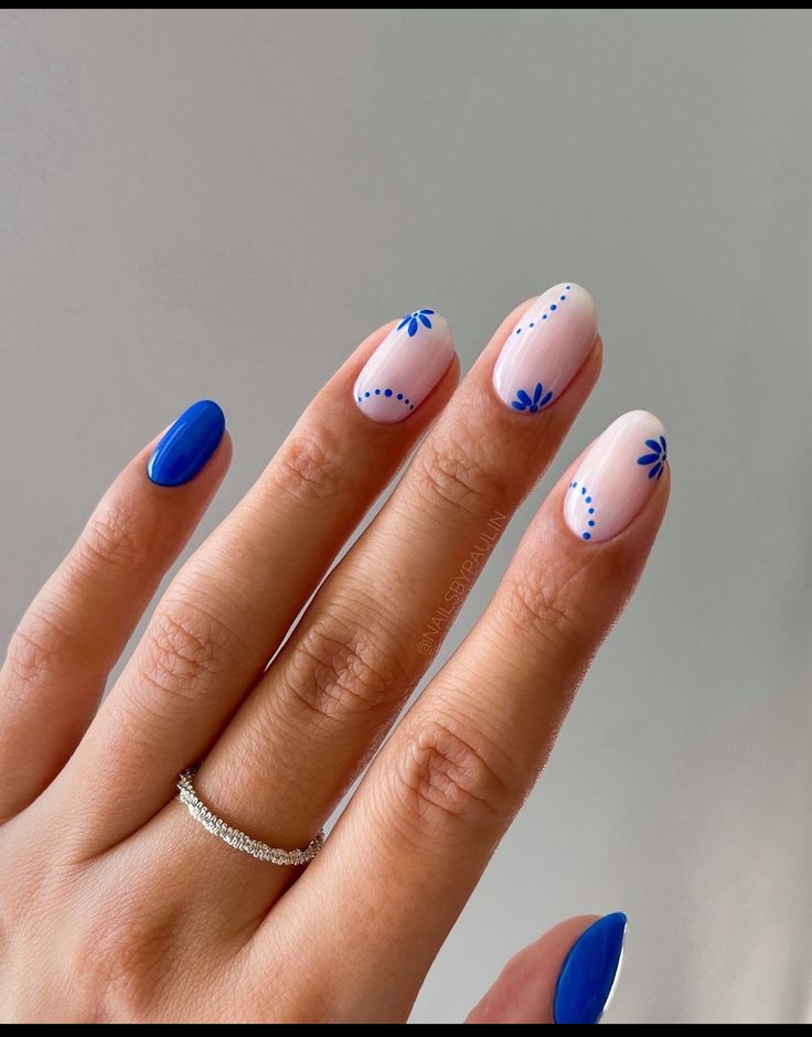 Whimsical Nail Design: Soft Pastels with Bold Blue Accents and Floral Patterns