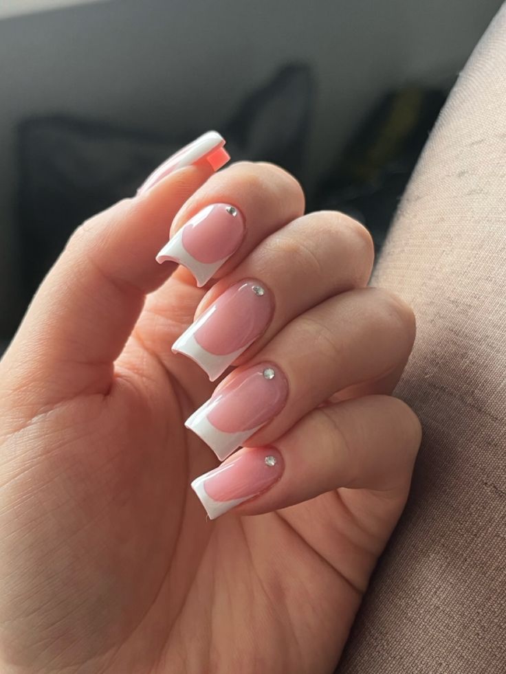 Chic Soft Pink Manicure with White French Tips and Rhinestone Accents.