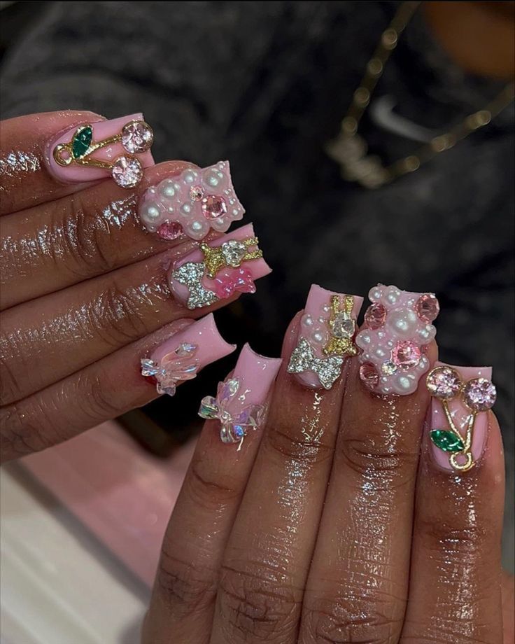 Playful Pastel Pink Nail Design with Embellishments and Whimsical Motifs.