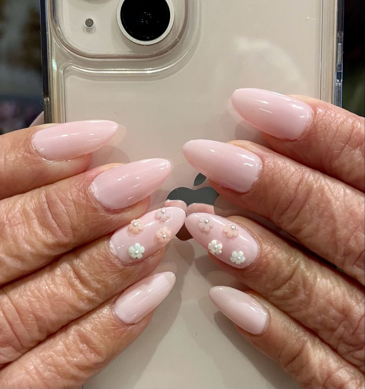 Delicate Almond-Shaped Nails with Soft Pink Polish and Floral Accents.