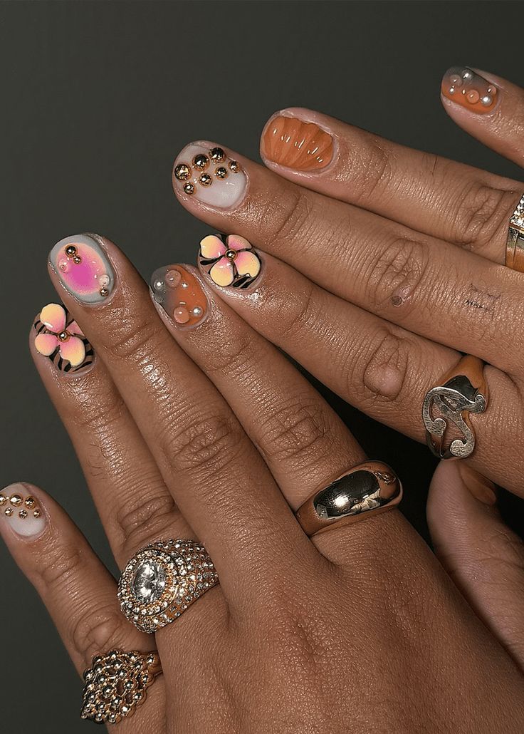 Vibrant Nail Art: Floral Designs and Elegant Embellishments in Soft Pastels and Glamorous Metallics.