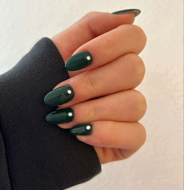 Sophisticated Green Almond-Shaped Nails with Gemstone Accents for Any Occasion.