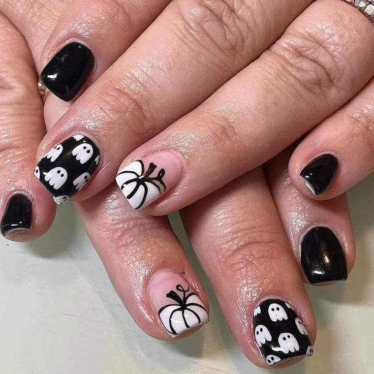 Festive Halloween Nail Design with Black and White Ghosts, Pumpkins, and Spiders