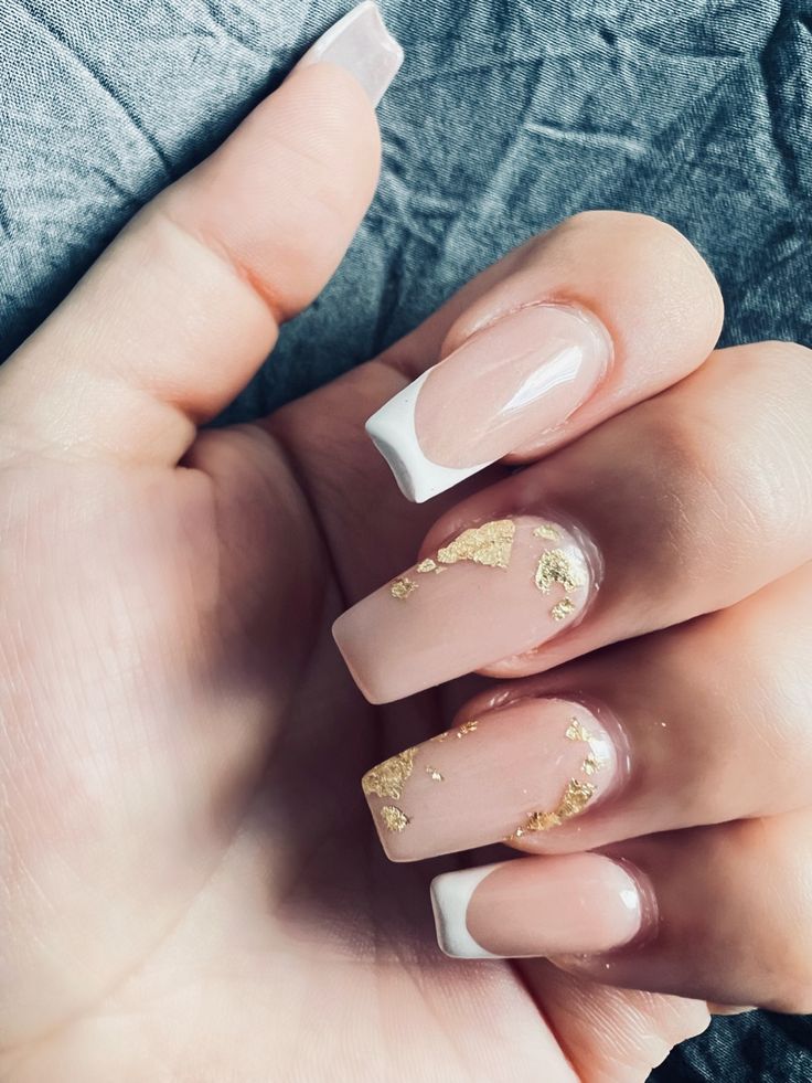 Sophisticated Nude Nail Design with Golden Leaf Accents and Classic French Tips.