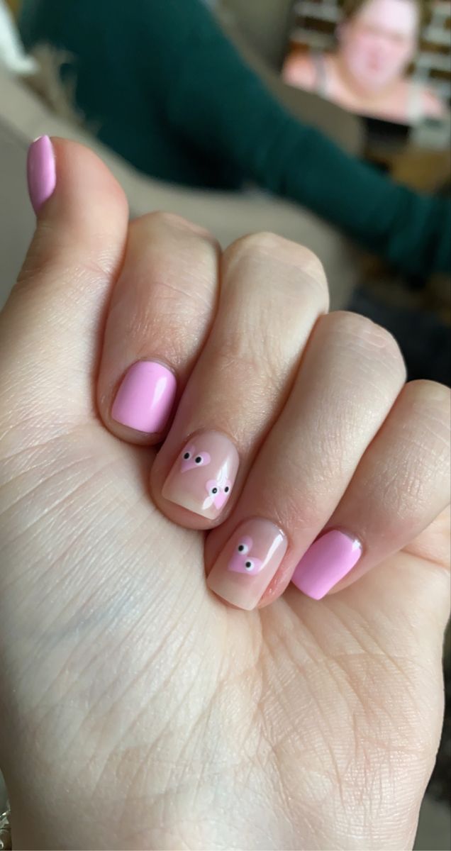 Whimsical Pink Nail Design with Cute Accents and Eye Embellishments.