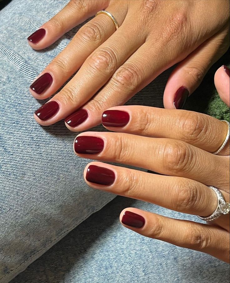 Sophisticated Burgundy Manicure with Glossy Finish and Modern French Tip Detail.