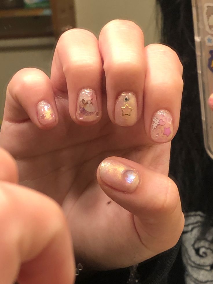 Charming Pastel Nail Design with Whimsical Accents and Sparkly Embellishments.