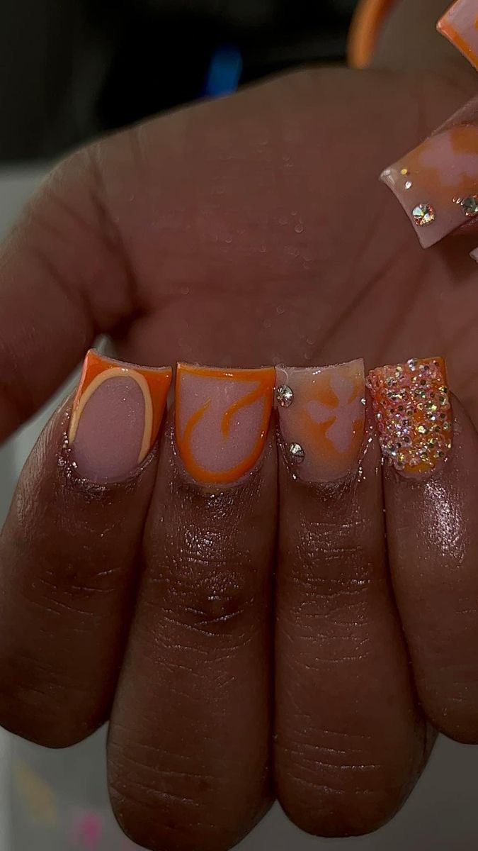 Bold Peach and Orange Nail Design with Abstract Swirls and Glamorous Accents