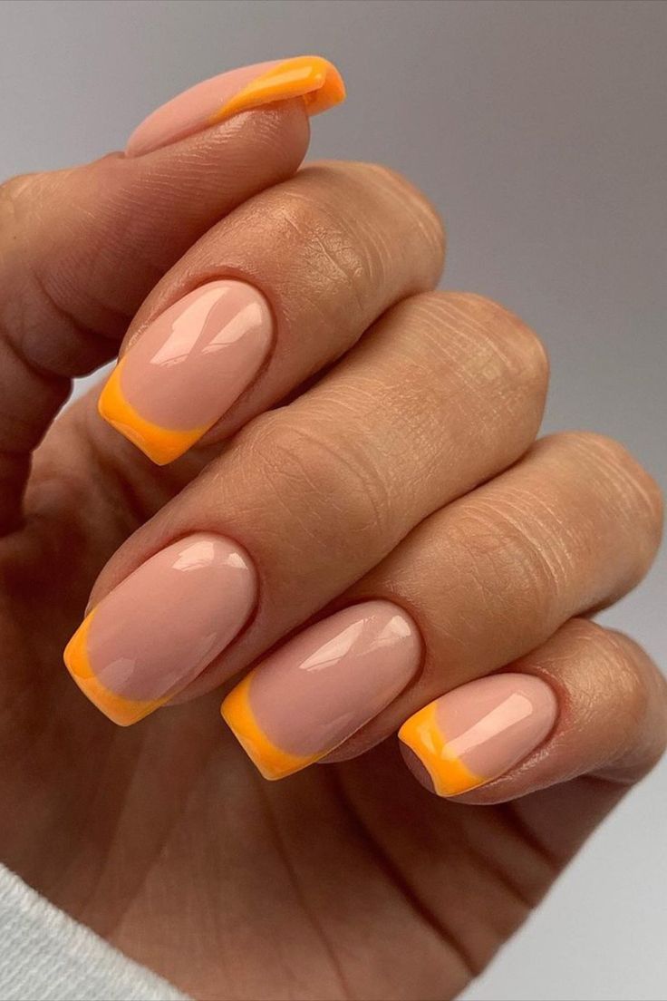 Chic Two-Tone Nail Design: Soft Nude Base with Vibrant Orange Tips for a Playful Statement.