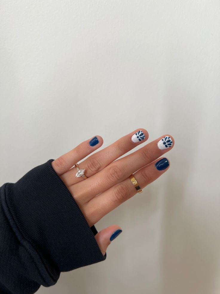 Elegant Nail Design: Deep Navy Blue and Crisp White with Intricate Floral Accents.