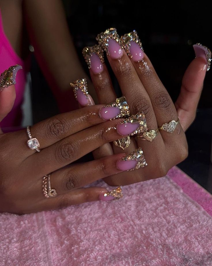 Elegant Soft Pink Nail Design with Gold Accents and Sparkling Tips.