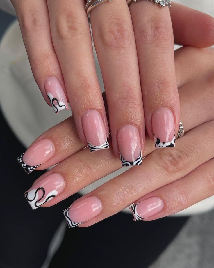 Chic Soft Pink and Black Nail Design with Whimsical French Tips.