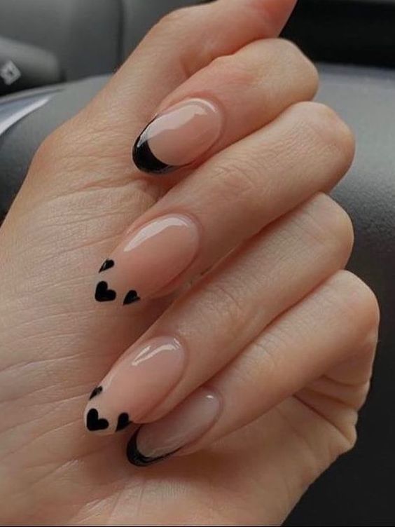 Chic Nude and Bold Black Nail Design with Playful Heart Tips.