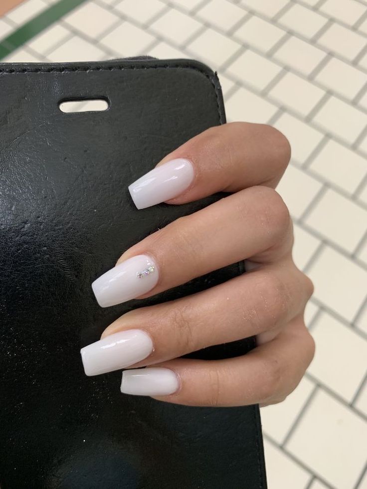 Timeless Elegance: Chic White Acrylic Nails with Subtle Crystal Accent.