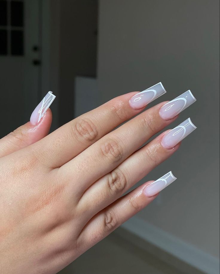 Chic Nude and White Long Nail Design with Glossy Finish and Intricate Details.