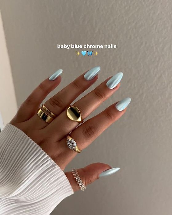 Elegant Baby Blue Chrome Nails with Glossy Finish Complemented by Delicate Rings for a Chic Aesthetic.