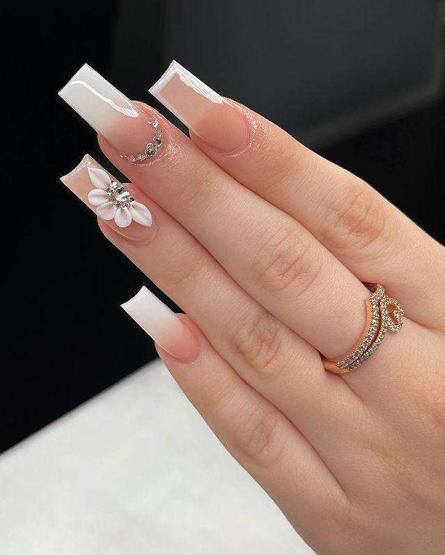 Sophisticated Long Square French Tip Nails with Floral Accents and Embellishments.