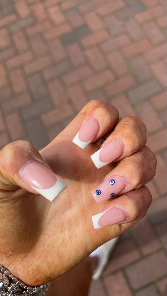 Sophisticated Manicure: Nude Base with White Tips and Whimsical Blue Eye Motifs