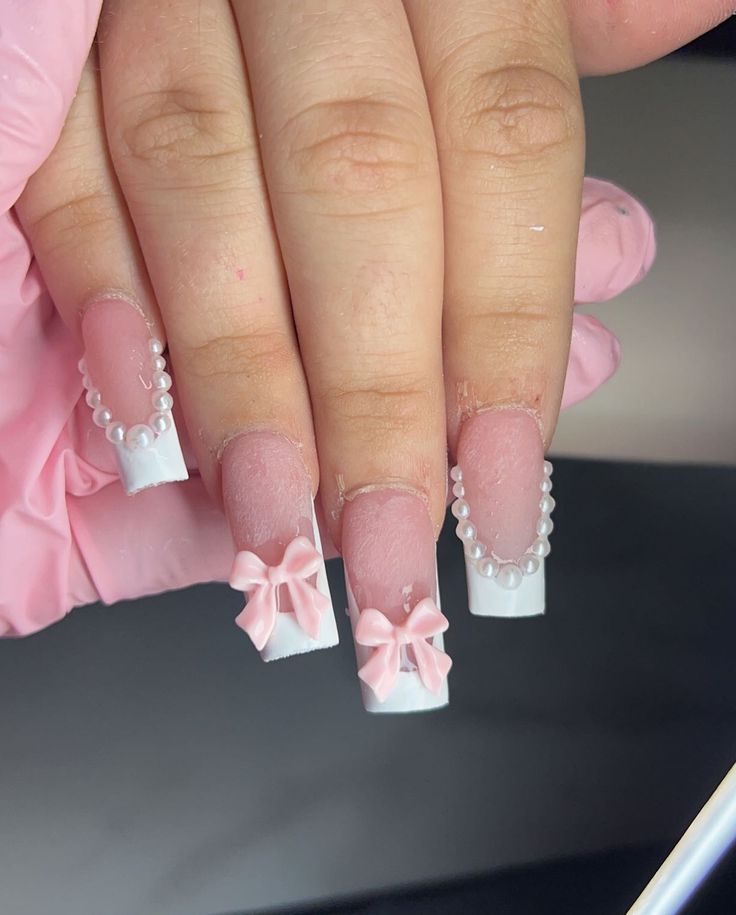 Charming Pink and White Nail Design with Bows and Pearls for Elegant Occasions.