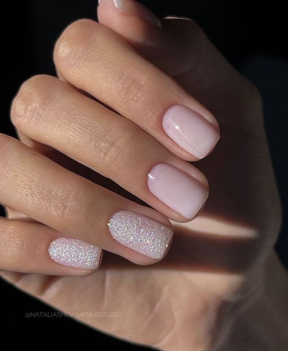 Elegant Soft Pink Nail Design with Glossy Finish and Glitter Accents.