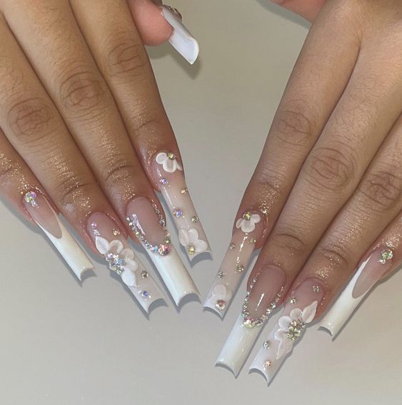 Elegant Floral Nail Art with Long Tapered Tips and Rhinestones.