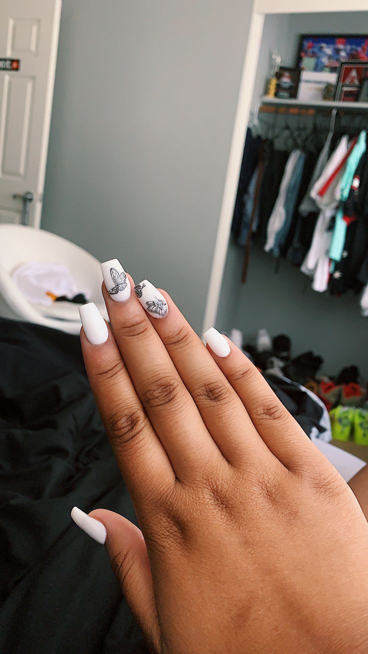 Elegant White Nails with Intricate Accent Art for a Stylish, Modern Look.