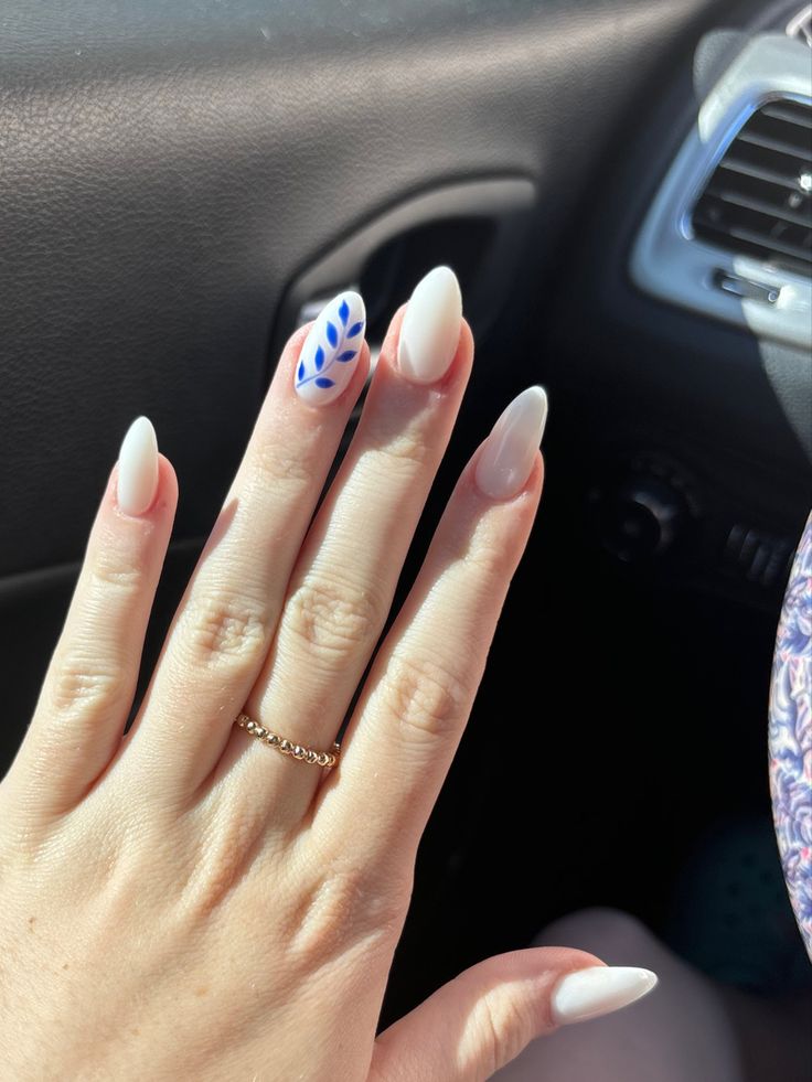 Chic Almond-Shaped Nails with Glossy White and Vibrant Blue Leaf Accent