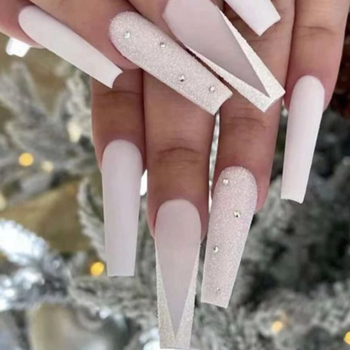 Sophisticated Stiletto Nail Design with Matte White, Glitter Accents, and Rhinestones