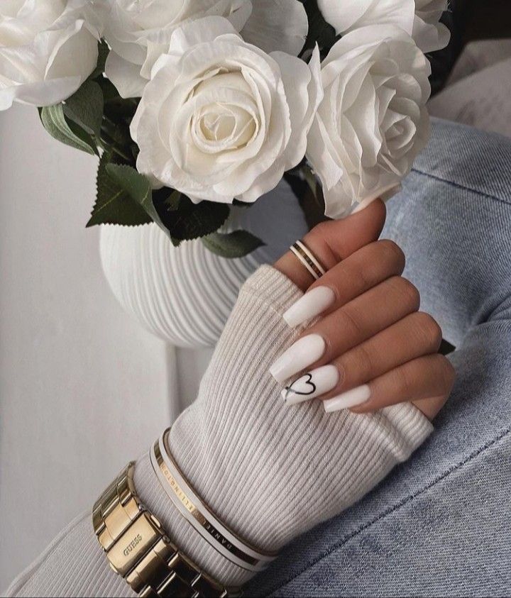 Charming Soft White Nail Design with Heart Accent Elevates Stylish Yet Relaxed Aesthetic.