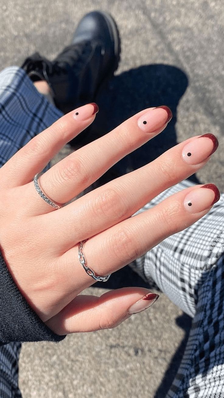 Trendy Chic Nail Design: Bold Red Tips and Playful Black Dots on Minimalist Nude Base