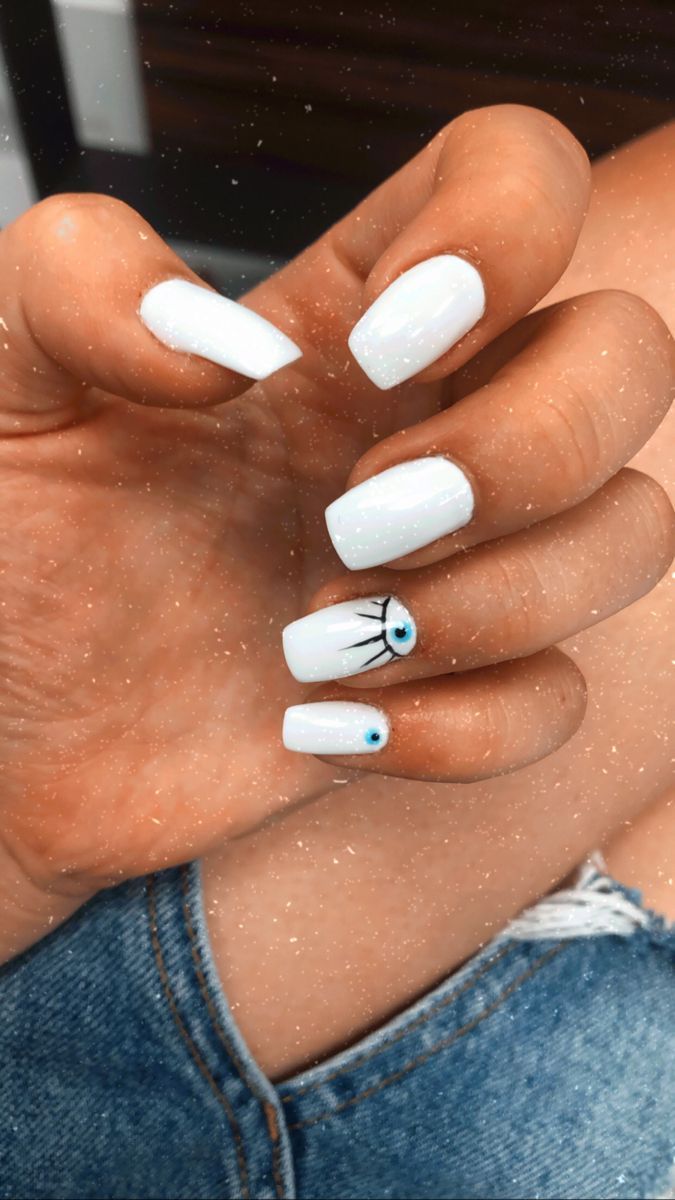 Chic White Nail Design with Glossy Finish and Artistic Blue Eye Accents.