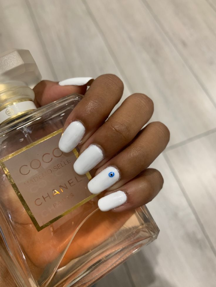 Sophisticated Minimalist White Nails with Blue Gem Accent for Effortless Elegance.