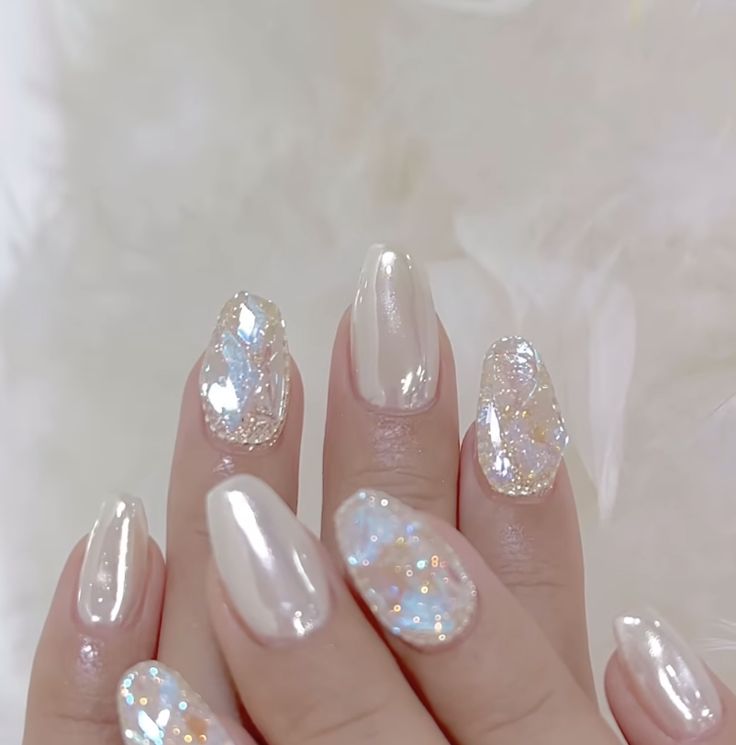 Elegant Pearlescent Nail Design with Shimmering Glitter Accents and Geometric Patterns.