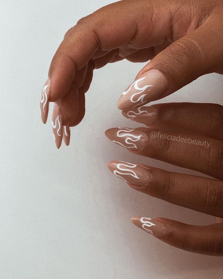 Elegant Nude Nail Design with Artistic White Flame Patterns.