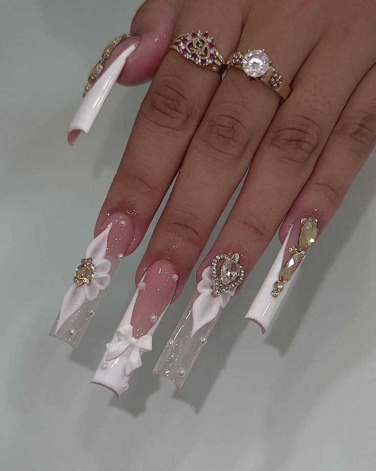 Elegant Long Acrylic Nail Design with Glossy White Finish and Intricate Embellishments.