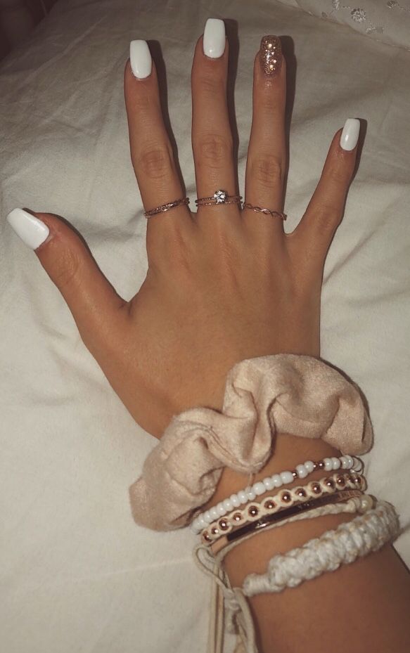 Chic White Manicure with Glossy-Textured Finish and Sparkling Accent Nail.