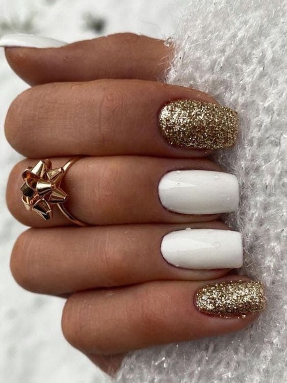 Sophisticated Nail Design with Classic White and Glittering Gold Accents.