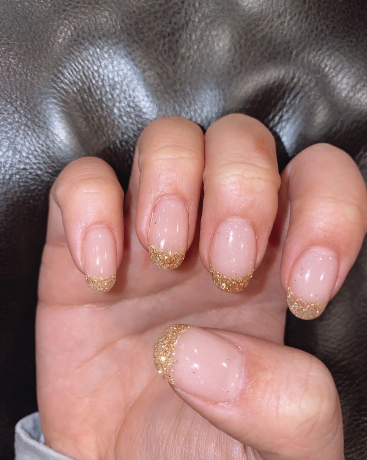 Elegant Nude and Gold Glitter Nail Design: A Timeless Blend of Simplicity and Glamour.