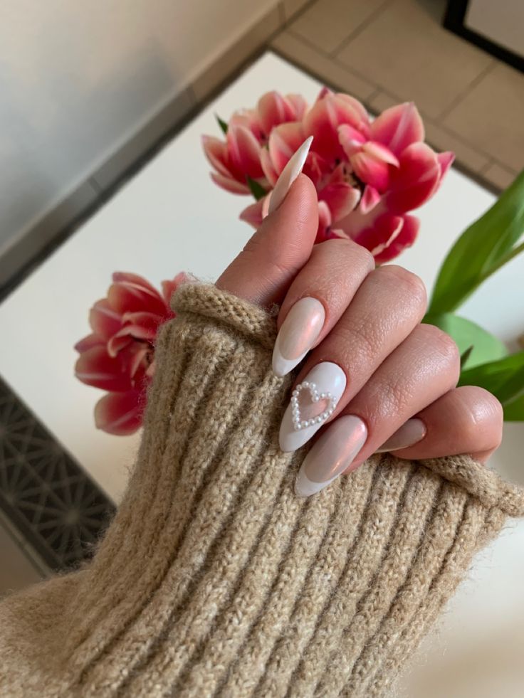 Chic Nail Design: Soft Nude and Glossy White with Pearl-Embellished Heart Accent.