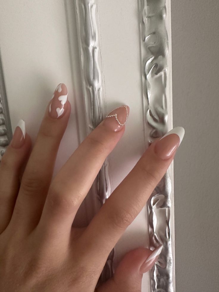 Chic Elegant Nail Design with Glossy Nude, White Tones, Heart Patterns, and Chain Accents.