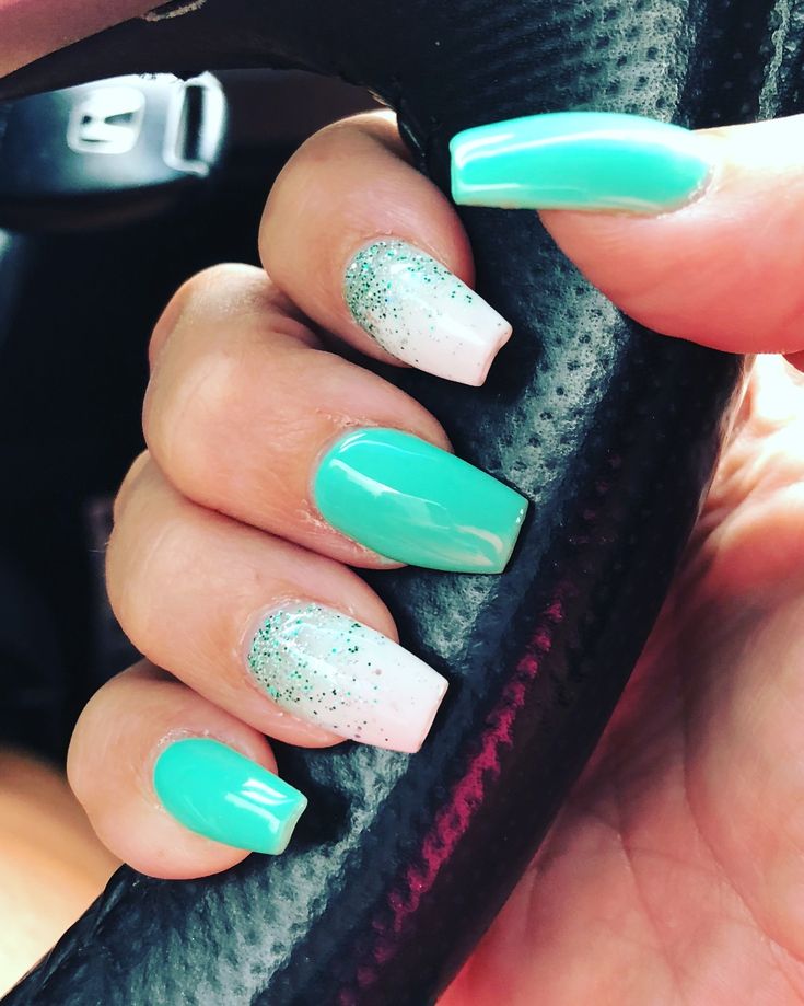 Vibrant Turquoise Ombre Nail Design with Sparkly White and Glitter Accents for a Tropical Flair.