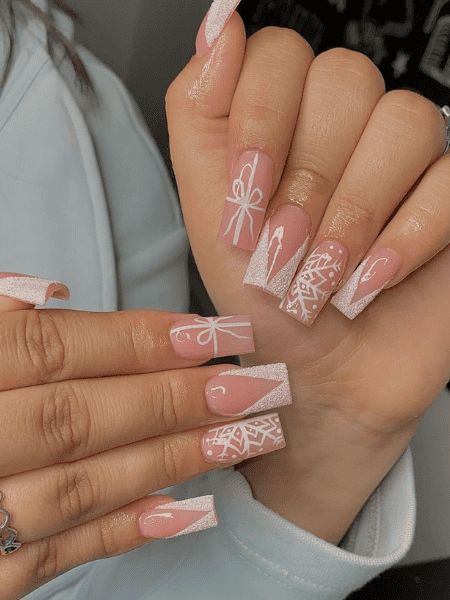 Chic Nail Design: Soft Pink Base with Intricate White Art and Stylish Finishes.