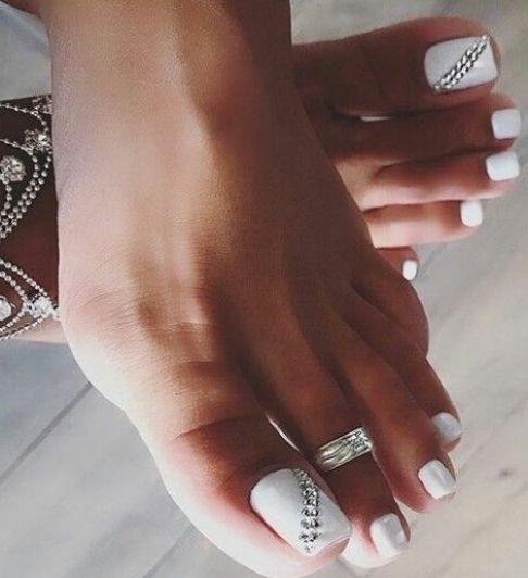 Chic White Nail Design with Glossy Finish and Rhinestone Accents for Elegant Summer Looks.