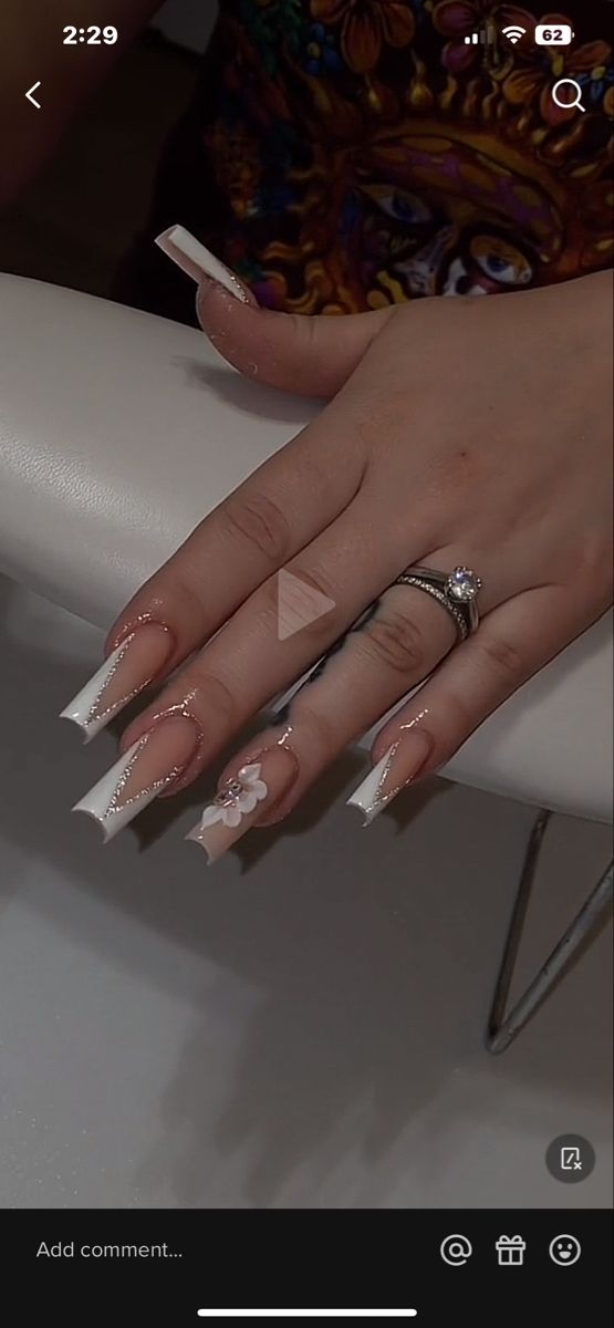 Sophisticated French Tip Acrylic Nails with Floral Accents and Shimmering Embellishments.